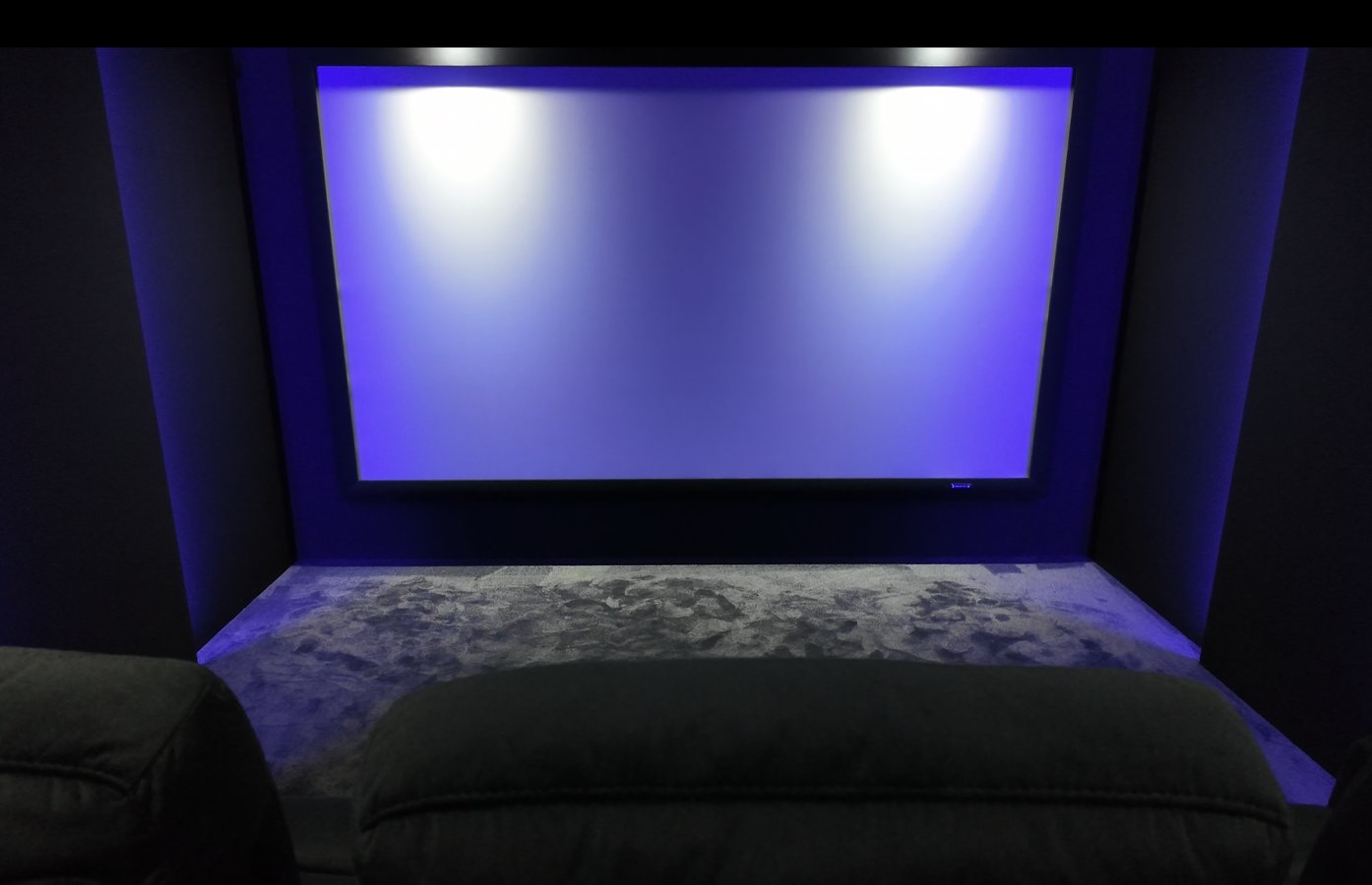 Modernes dediziertes Heimkino mit großer Leinwand, akustisch optimiertem Innenausbau und Kinosesseln als Beispiel für ein professionell geplantes Heimkino ab etwa 80.000 Euro.